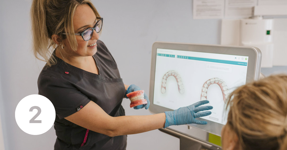 Dentist showing patient the scan results on a screen